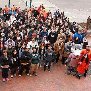 A large group of students gather together for an ariel photo with Wally Wolf.
