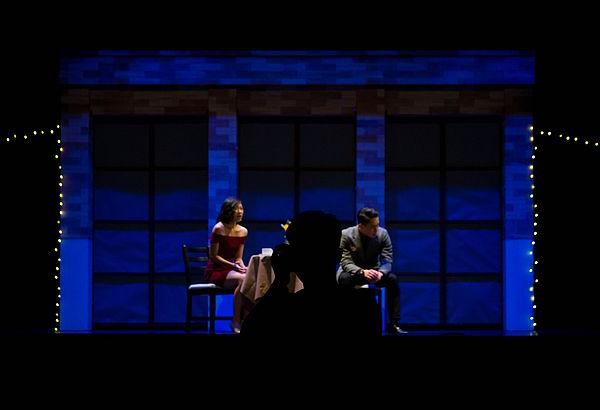 两个人站在灯光昏暗的舞台上